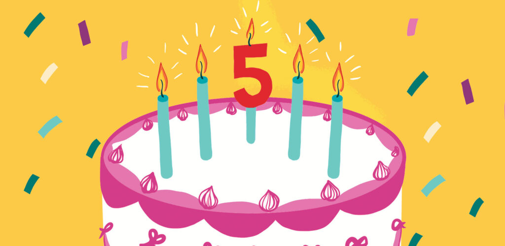 A birthday cake with 5 candles, surrounded by confetti